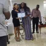 woman accepting a certificate at ceremony at eye clinic in Abuja